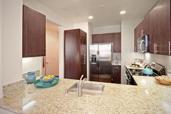 a kitchen with stainless steel appliances and granite counter tops at The Vines at Riverpark, LLC, Oxnard, CA
